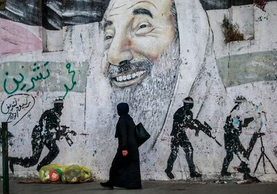 A Palestinian woman walks past a mural of Hamas's late leader Sheikh Ahmed Yassin in Gaza city. EPA
