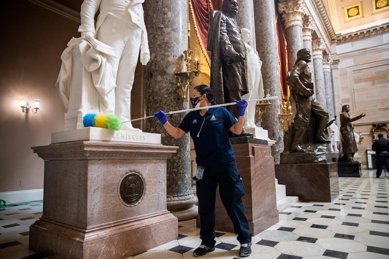 A cleaning crew dusts residue from the pedestals of the statues in Statuary Hall inside the US Capitol in Washington.  EPA