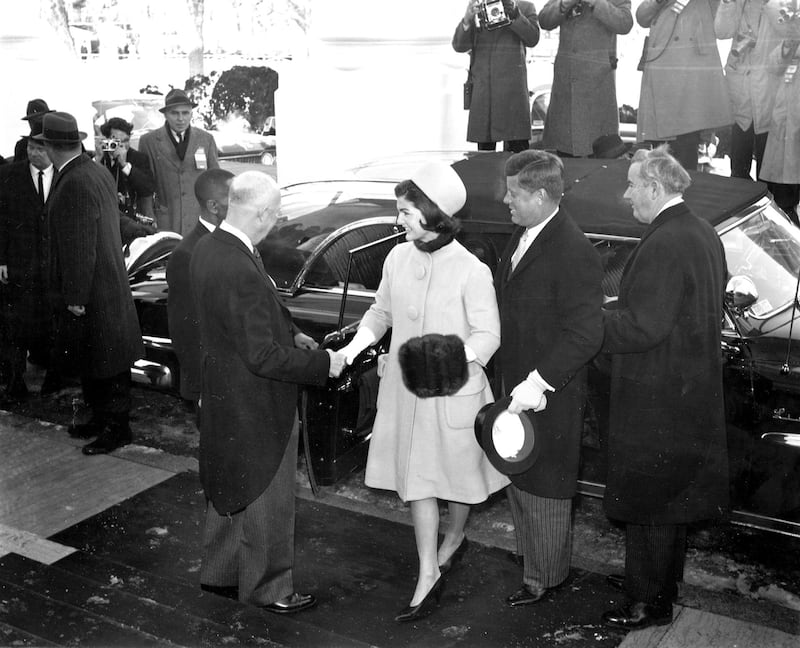 U.S. President Dwight Eisenhower shakes hands with Jacqueline Kennedy as she and President-elect John F. Kennedy arrive at the North Portico of the White House in Washington, D.C., on inauguration day, Jan. 20, 1961.  (AP Photo)