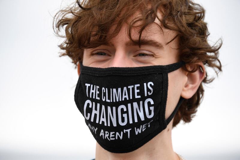 A climate activist wears a protective face mask on Gyllyngvase Beach in Falmouth, Cornwall. AP Photo