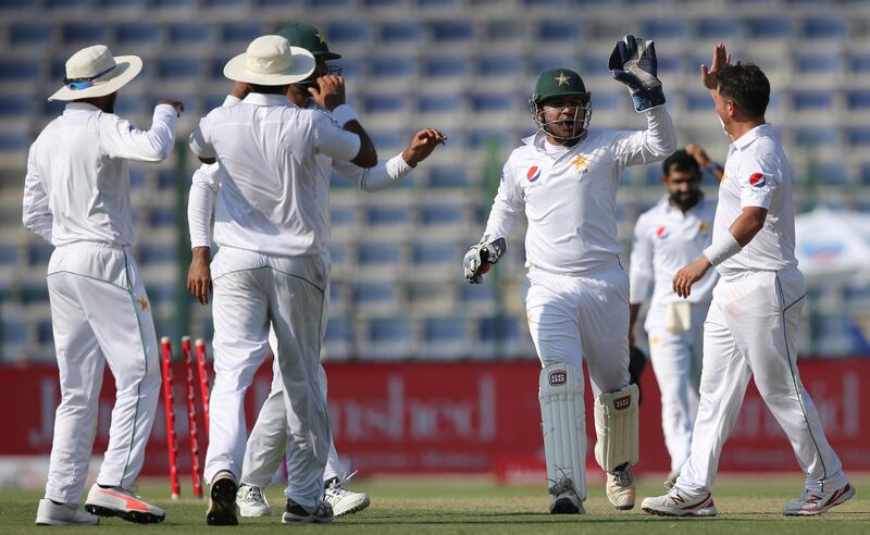 Pakistan's players celebrate the dismissal of Sri Lanka's batsman Dimuth Karunaratne during their 1st Test cricket match in Abu Dhabi, United Arab Emirates, Thursday, Sept. 28, 2017. (AP Photo/Kamran Jebreili)