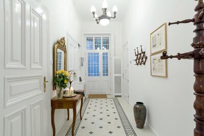 The entrance hall features an antique mirror and coat stand