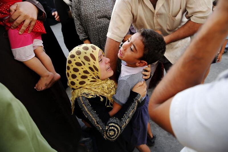 A Palestinian woman whose husband was killed during the Israeli ground offensive, embraces her son after finding him alive at the hospital. Finbarr O’Reilly / Reuters