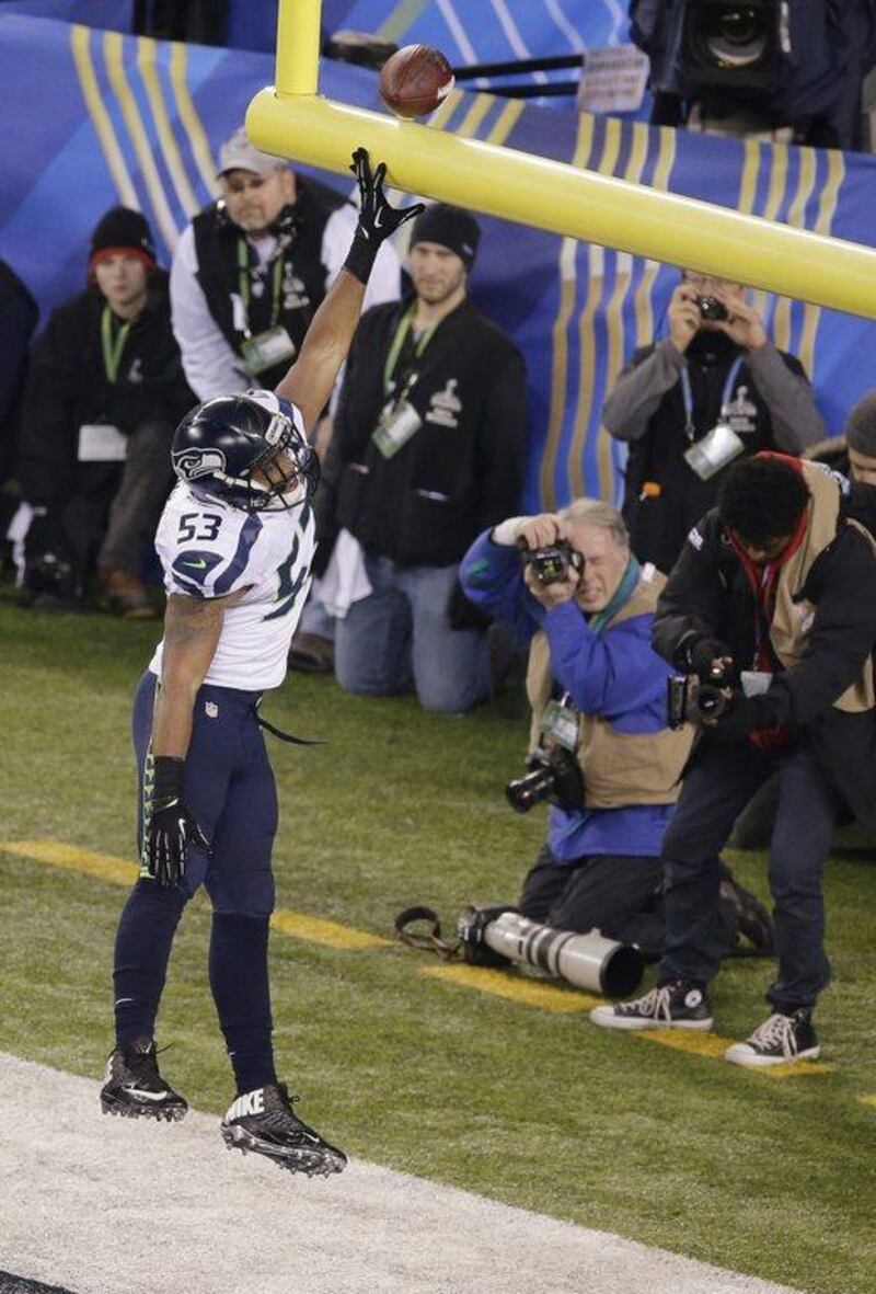 Malcolm Smith of the Seahawks celebrates after returning an intercepted a pass for a touchdown during the first half of the Super Bowl. Charlie Riedel / AP