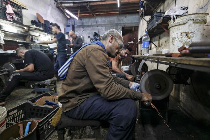 Knifesmiths in Gaza City sharpen blades to be used to slaughter animals for Eid Al Adha. AFP