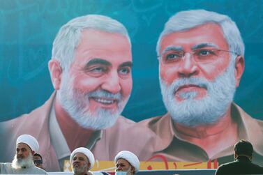 Iraqi clerics stand near a banner in Baghdad depicting senior Iranian military commander Qassem Suleimani and Iraqi militia commander Abu Mahdi Al Muhandis. Reuters