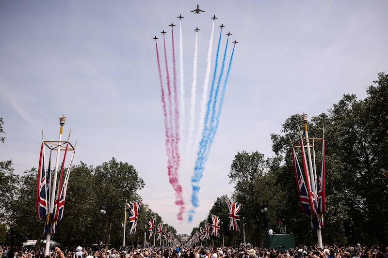 Members of the public cheer as they watch the Royal Air Force Aerobatic Team, the Red Arrows during the King's Birthday Parade, 'Trooping the Colour', in London. AFP