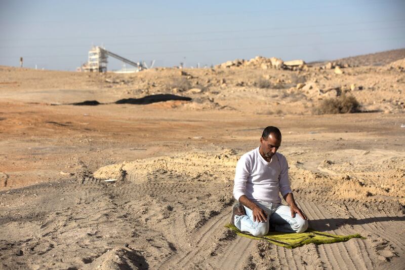 Achmed ,43, prays during the late afternoon before driving a truck load of 38 tons of phosphate to Ashdod from an industrial area in Rotem, Israel where phosphate is mined in the Negev,Desert ,Febuary 4,2018."Yes, I heard about that they want to build in Arad and its dangerous to build close to people, its not healthy, I get headaches when I am inside the factories loading my truck ".He said that he got used to the irritations it causes to his eyes .

(Photo by Heidi Levine for The National).