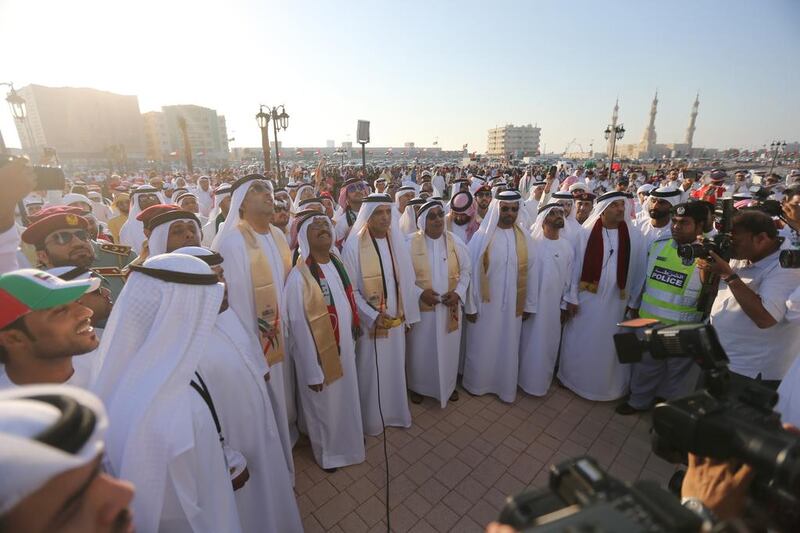 The Ruler of Ras Al Khaimah, Sheikh Saud (centre), arrives to unveil a large UAE flag as the nation celebrates its 42nd birthday. Sammy Dallal / The National