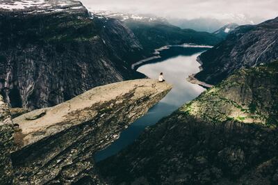 Woman sitting on the edge of the Trolltunga rock 