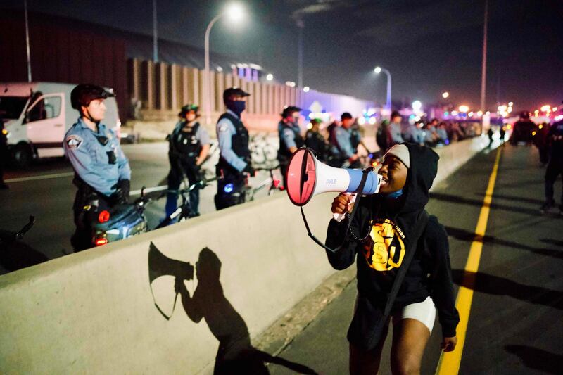 Police officers line up alongside interstate 94 blocked by protestors marching against racism and issues with the presidential election in Minneapolis, Minnesota.  AFP