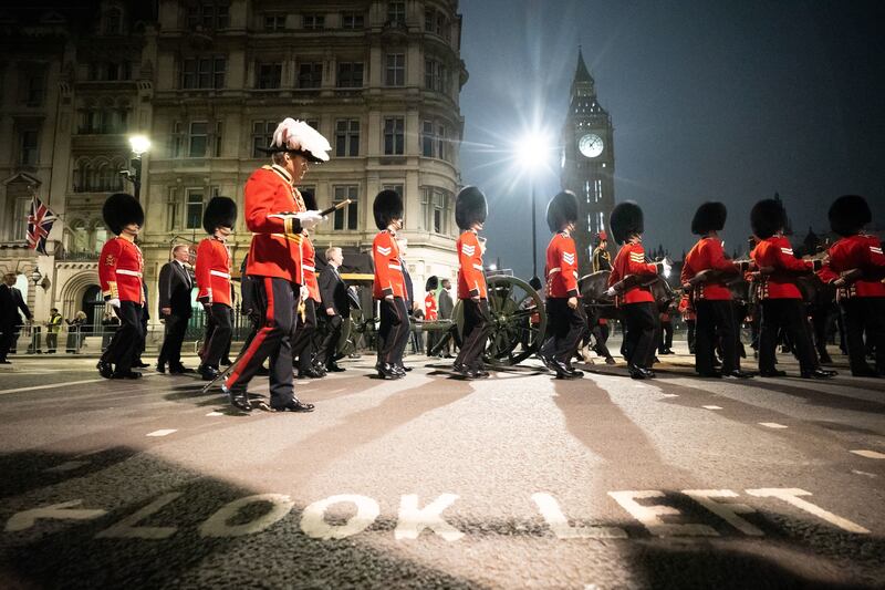 Grenadier Guards march past Big Ben in central London. PA