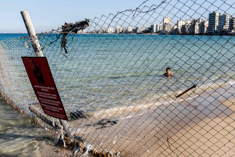 A child swims behind a Turkish Army sign in the fenced-off area of Varosha in Famagusta, Northern Cyprus. Turkish President Recep Tayyip Erdogan is expected to visit the abandoned beach resort of Varosha.