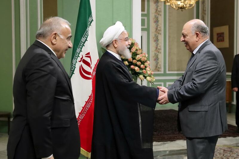 Iranian President Hassan Rouhani shake hands with Iraqi Oil Minister Thamer Ghadhban. Reuters