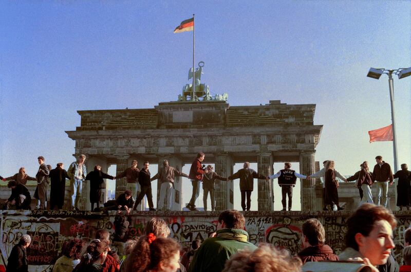 Berliners sing and dance on top of the Berlin Wall to celebrate the opening of East-West German borders in Berlin. Thousands of East German citizens moved into the West after East German authorities opened all border crossing points to the West. In the background is the Brandenburg Gate. AP Photo