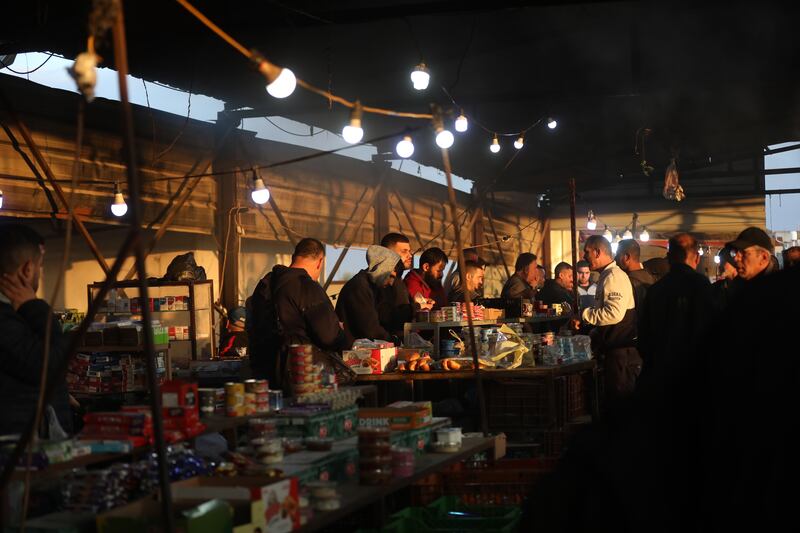Palestinian workers buy food before crossing the Tayba check point to go to work in Israel on May 1. EPA