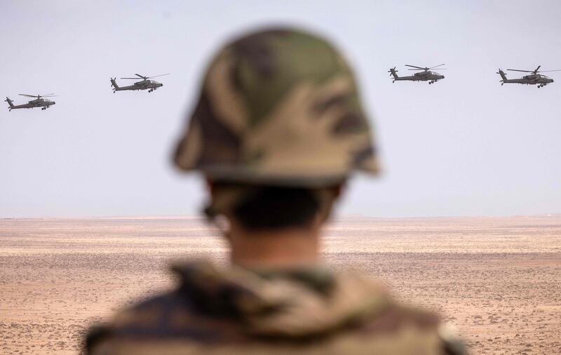 US AH-64 Apache attack helicopters fly over Tan-Tan in formation.