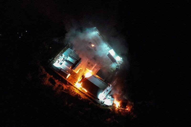 A UNHCR first reception center for the refugee and migrant arrivals in Skala Sykamias is seen on fire as local residents block the area around it.   AFP