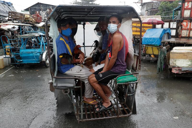 Residents evacuate with their chickens to safer grounds as rains from a typhoon locally known as Goni start to pour in Manila. AP Photo