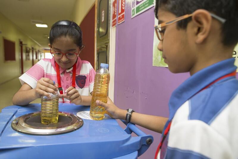 Pupils at Dubai’s Kindergarten Starters put cooking oil in a collection bin so it can be recycled in to biofuel. Antonie Robertson / The National