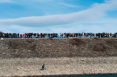 TOPSHOT - People gather on the banks of the Gazivode lake in northern Mitrovica on September 8, 2018. Controlled by Serbs but a power source for Kosovo, the disputed blue-green waters of Lake Gazivode reflect the thorny relationship between the former war foes and the difficulty of any attempt to change their borders. The 24-kilometre (15-mile) reservoir snakes across the frontier dividing Serbia and Kosovo, two neighbours locked in a diplomatic dispute twenty years after they were split by war.  / AFP / Armend NIMANI
