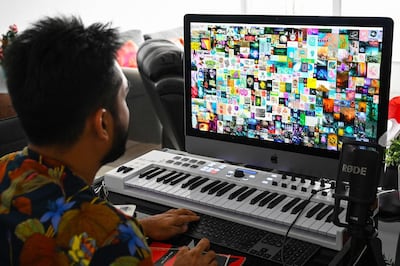 This picture taken on April 7, 2021 shows blockchain entrepreneur Vignesh Sundaresan, also known by his pseudonym MetaKovan, showing the digital artwork non-fungible token (NFT) "Everydays: The First 5,000 Days" by artist Beeple in his home in Singapore. Last month the programmer bought the world's most expensive NFT for $69.3 million, highlighting how virtual work is establishing itself as a new creative genre.  - RESTRICTED TO EDITORIAL USE - MANDATORY MENTION OF THE ARTIST UPON PUBLICATION - TO ILLUSTRATE THE EVENT AS SPECIFIED IN THE CAPTION

TO GO WITH Singapore-US-arts-IT, INTERVIEW by Catherine LAI
 / AFP / Roslan RAHMAN / RESTRICTED TO EDITORIAL USE - MANDATORY MENTION OF THE ARTIST UPON PUBLICATION - TO ILLUSTRATE THE EVENT AS SPECIFIED IN THE CAPTION

TO GO WITH Singapore-US-arts-IT, INTERVIEW by Catherine LAI

