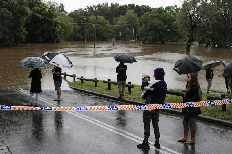 People gather on a flooded street in the suburb of Windsor as the state of New South Wales experiences widespread flooding and severe weather. Reuters
