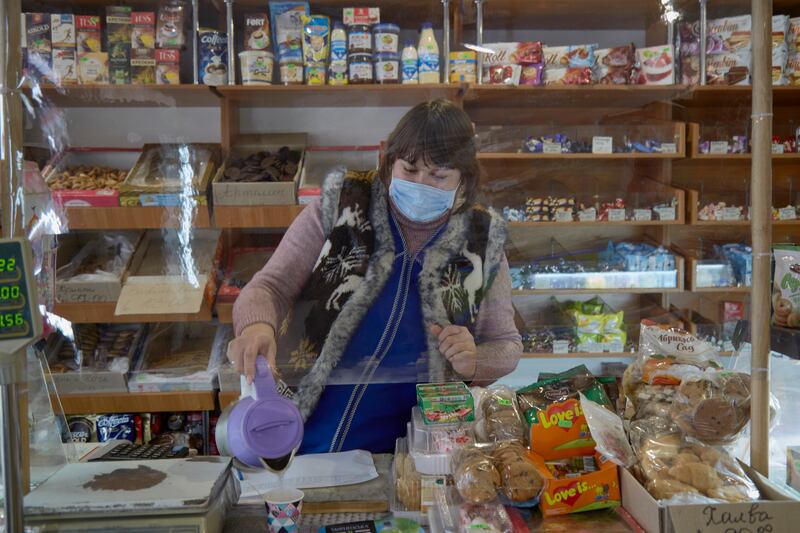 A salesperson works in a grocery store in Orlivka. Tensions with Russia have hit the economy hard, Ukrainian authorities say. Getty Images