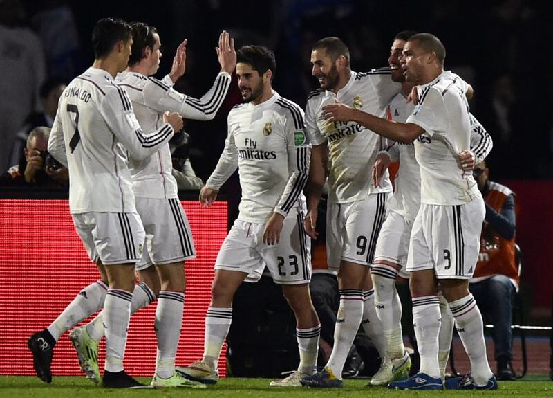 Real Madrid’s players congratulate their teammate Sergio Ramos after he scored a goal against San Lorenzo during their FIFA Club World Cup final football match at the Marrakesh stadium in the Moroccan city of Marrakesh on December 20, 2014. AFP PHOTO / JAVIER SORIANO