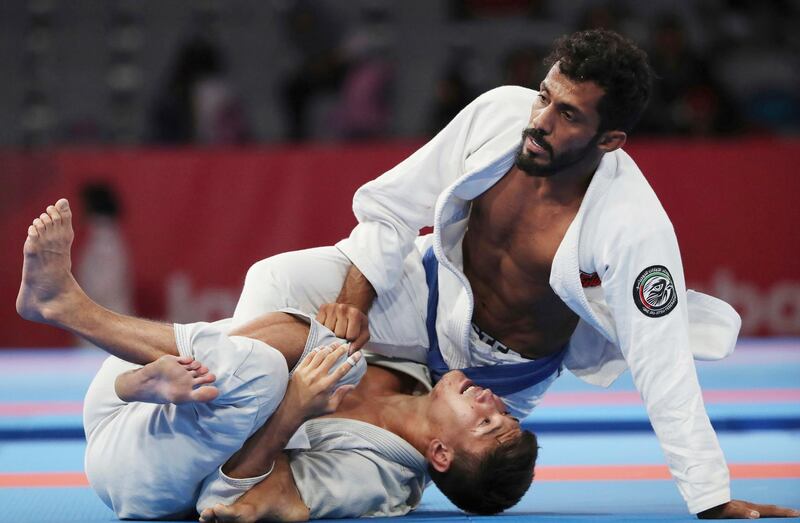 Talib Al Kirbi of the UAE, top, fights Kazakhstan's Nartay Kazhekov during the men's 69kg semi-final. Firdia Lisnawati / AP Photo
