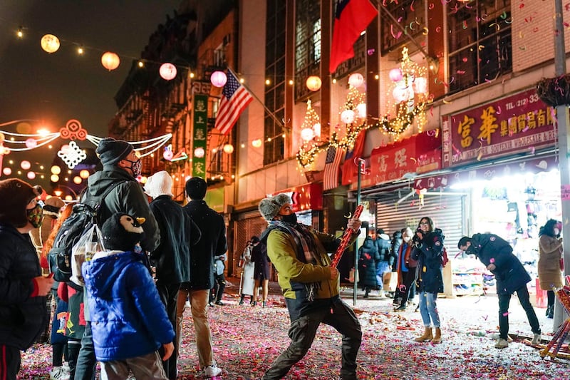 People gather on Mott Street for Lunar New Year Friday, Feb. 12, 2021, in the Chinatown neighborhood of New York. The celebration marks the Year of the Ox in the Chinese calendar. (AP Photo/Frank Franklin II)