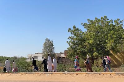 People displaced by the conflict in Sudan walk along road in Wad Madani, the capital of Al Jazirah state, on December 16, 2023. AFP