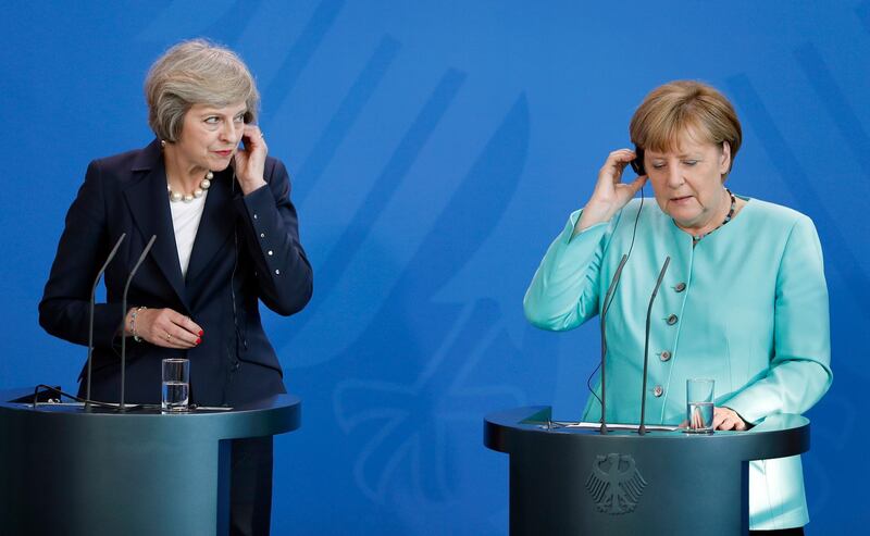 FILE - In this July 20, 2016 file photo German Chancellor Angela Merkel, right, and British Prime Minister Theresa May, left, hold their earphones during a joint news conference as part of a meeting at the chancellery in Berlin. Germany has viewed itself as Europeâ€™s anchor of stability for a dozen years under Chancellor Angela Merkel, but the collapse of her talks to form a new government now means months of political uncertainty. (AP Photo/Michael Sohn, file)