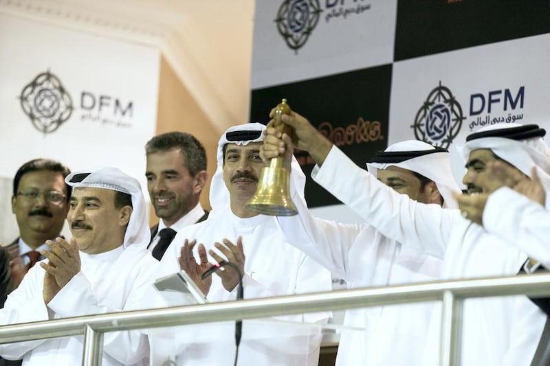 Raed Al Nuaimi, CEO of Dubai Parks & Resorts rings the bell to kick off the company's IPO. To his right stands Abdulla Al Habbai, chairman of Dubai Parks & Resorts, and Essa Kazim, chairman of Dubai Financial Market (DFM).  Reem Mohammed / The National



