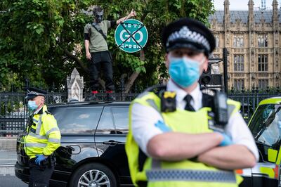 LONDON, ENGLAND - SEPTEMBER 10: An Extinction Rebellion demonstrator stands on top of a car as traffic comes to a stop in Parliament Square on September 10, 2020 in London, England. Extinction Rebellion Activists are holding ten days of climate action across the UK. Their activities began on September 1st. (Photo by Leon Neal/Getty Images)