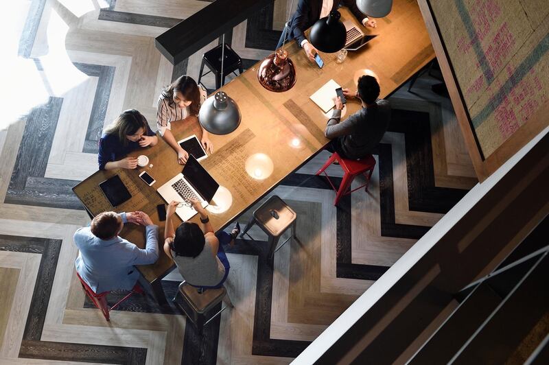 Young Chinese colleagues working together in a busy co-working space from above. Getty Images