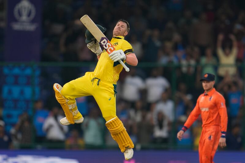 Australia's David Warner leaps to celebrate scoring a century. AP