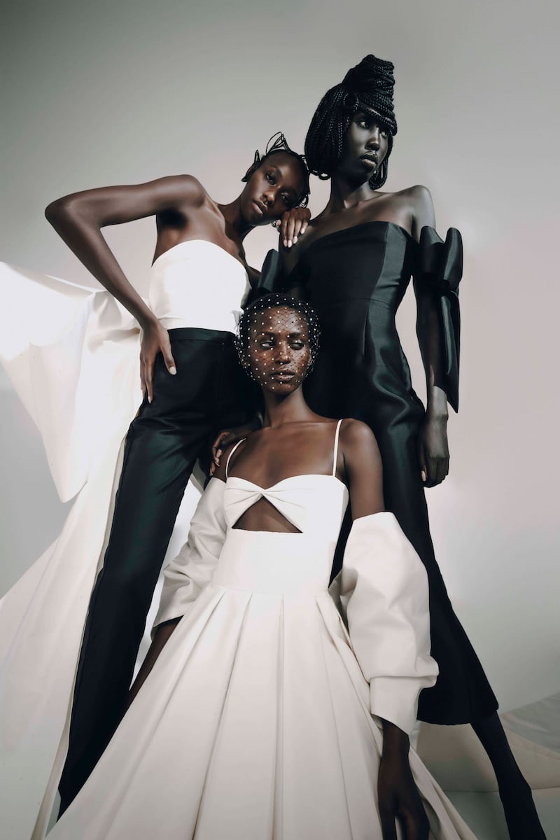 From left, Mitchell in an ivory silk bustier with bow and train; and tailored trousers; Kristine in a pleated mini dress with bow sleeves; and Nyajouk in a fitted cocktail dress with bow detail, all from Fatima Saad