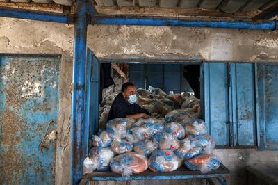 A Palestinian worker looks on as he prepares bags of food supplies at an aid distribution center run by United Nations Relief and Works Agency (UNRWA), at Beach refugee camp in Gaza City April 7, 2021. REUTERS/Mohammed Salem