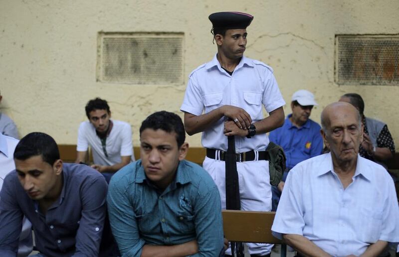 A police officer stands guard near Egyptians waiting for a polling station to open during the Egyptian presidential election in Cairo May 26, 2014. Amr Abdallah Dalsh/Reuters