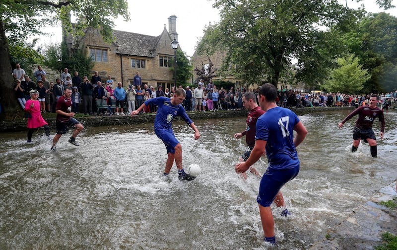 BOURTON-ON-THE-WATER, ENGLAND - AUGUST 27: Players from Bourton Rovers compete against each other  during the annual Bourton-on-the-Water Football Match played on the River Windrush on August 27, 2018 in Bourton-on-the-Water, England. (Photo by Catherine Ivill/Getty Images)
