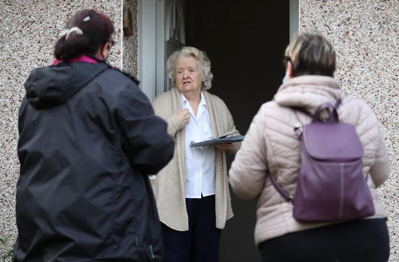 Volunteers hand out the Covid-19 home test kit to a resident in Goldsworth and St Johns in Woking. Reuters