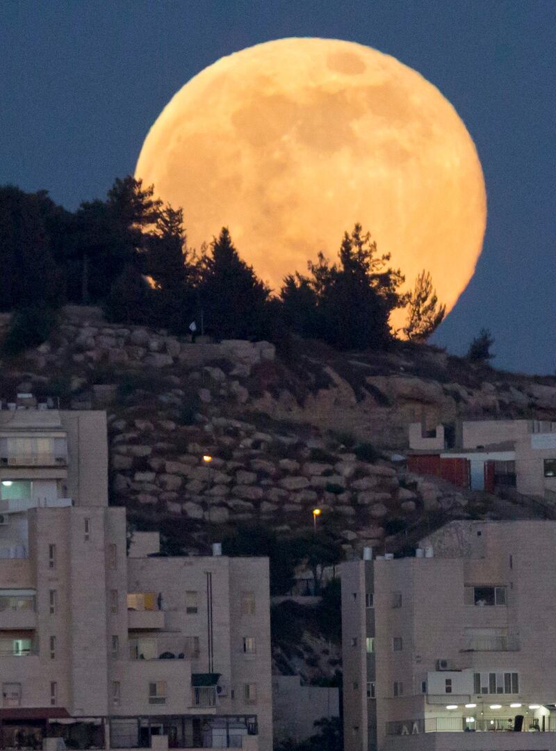 epa03756969 A full moon in the 'Perigee' phase rises over the Jerusalem neighborhood of Har El, 23 June 2013. The moon on 23 June evening will be at its closest distance to Earth, a constellation also known as 'supermoon,' in which the earth's trabant appears between 12 to 14 per cent larger and according to scientific sources also about 30 percent brighter than the normal full moon.  EPA/JIM HOLLANDER *** Local Caption ***  03756969.jpg