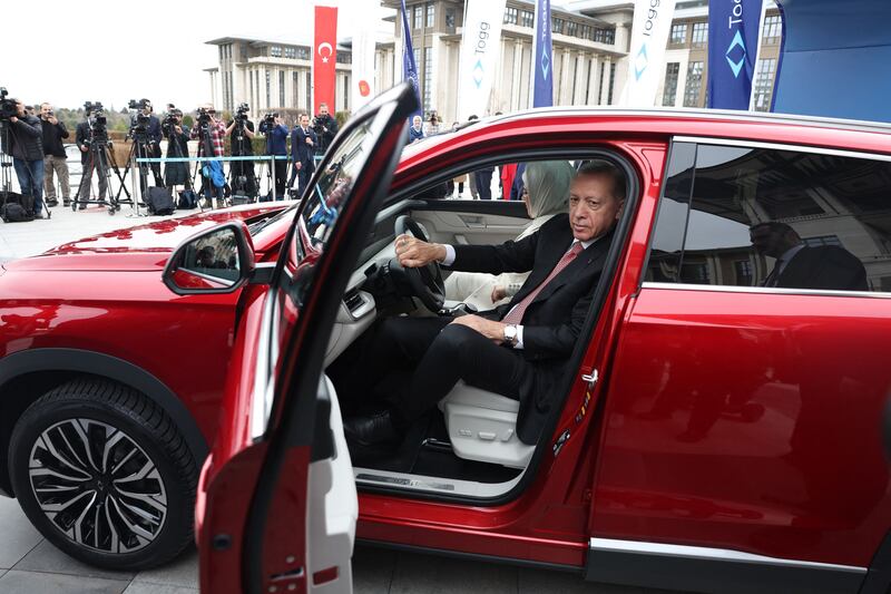 Turkey's President Recep Tayyip Erdogan and his wife Emine Erdogan (R) receive their Togg T10X, Turkey's first domestically-produced electric car, at the Presidential Complex in Ankara, on April 3, 2023.  (Photo by Adem ALTAN  /  AFP)