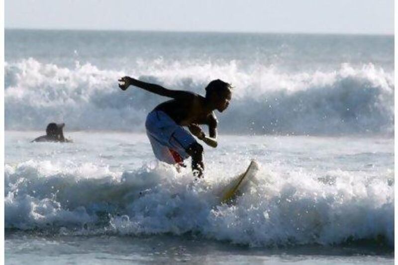 A Balinese surfer rides a small wave at Kuta beach. Getty Images