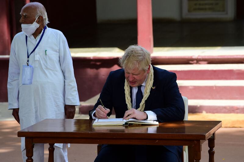 Boris Johnson signs a visitors' book at the Sabarmati Ashram, Ahmedabad. AFP