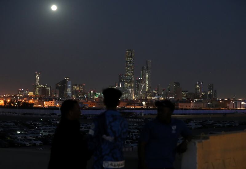 Fans watch as the Moon rises over Riyadh
