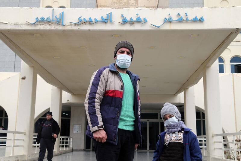 Visitors wearing protective face masks pose for a photograph after visiting Rafik Hariri University Hospital in Beirut, Lebanon.  Bloomberg