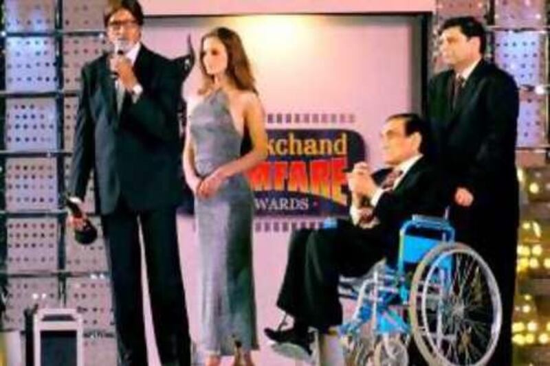 Bollywood legend Amitabh Bachchan (L) highlights well-known producer-director B.R. Chopra's (in a wheelchair) career before handing him the lifetime achievement award at the 49th annual Manikchand Filmfare awards in Bombay, 21 February 2004.  Chopra is Bollywood's veteran producer-director with a career spanning six decades comprising of numerous superhits and had recently produced the successful movie "Baghbaan" (Gardner) in 2003 starring Bachchan which was directed by his son Ravi Chopra (R). AFP PHOTO/Rob ELLIOTT