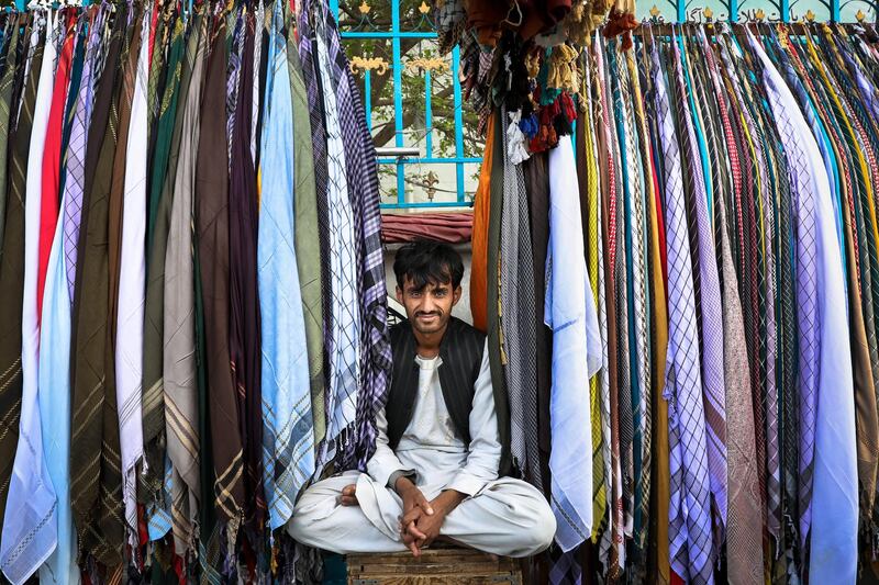 A scarf vendor poses for a photograph at a shop in Kabul, Afghanistan. EPA